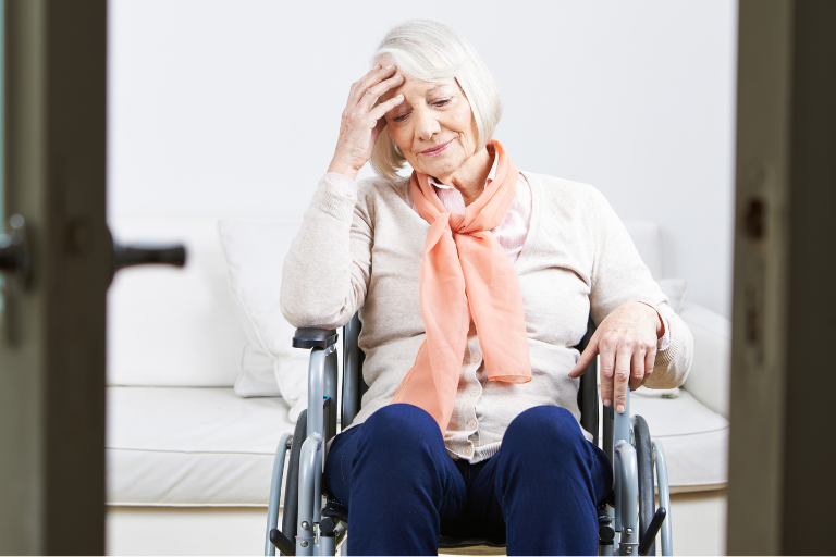 Seniorin in ihrem Rollstuhl in der Wohnung